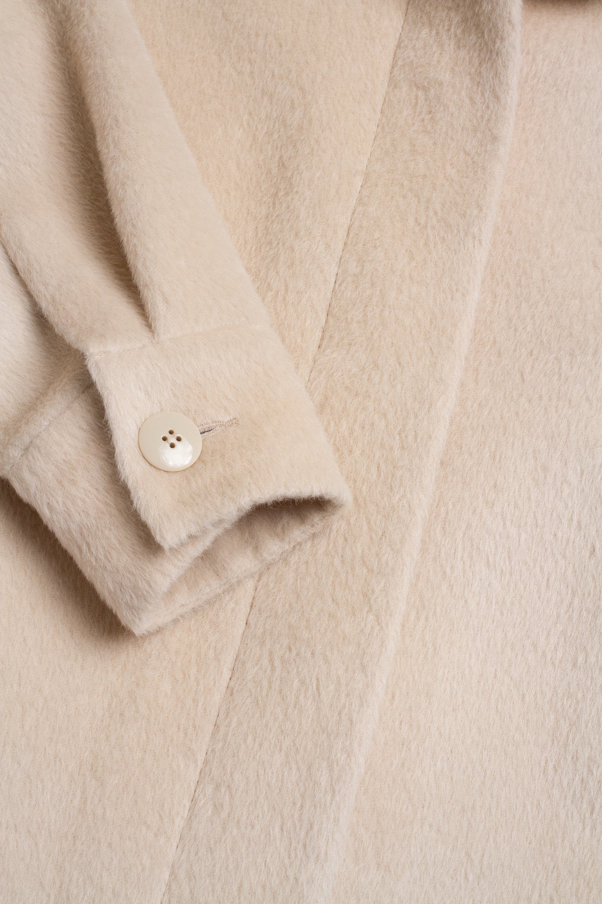Close-up of a beige coat with a button detail