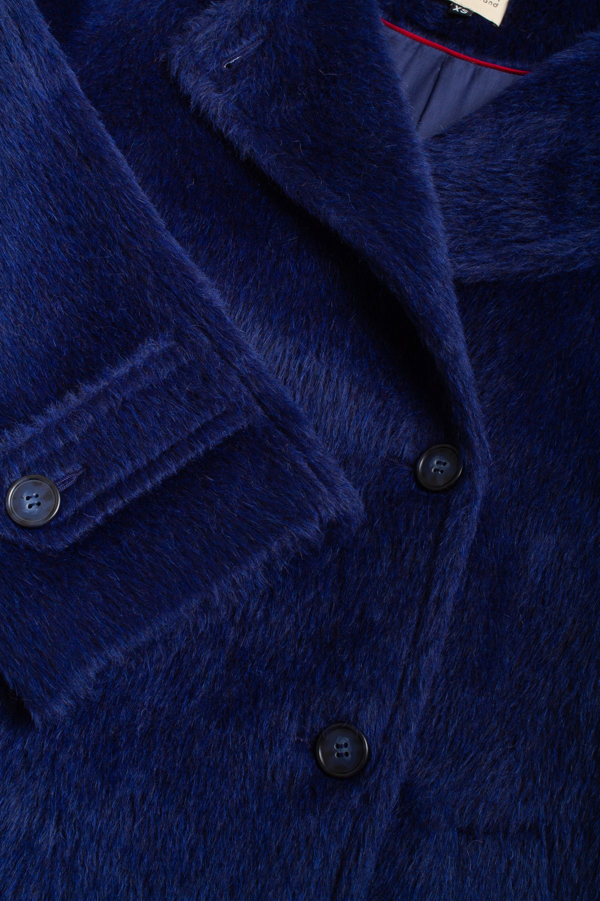 Close-up of a blue textured coat with buttons