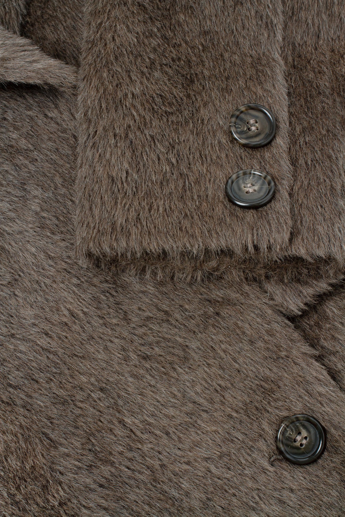 Close-up of a brown textured faux-fur or shearling-style garment with dark buttons, showing the fabric pile and collar detail.